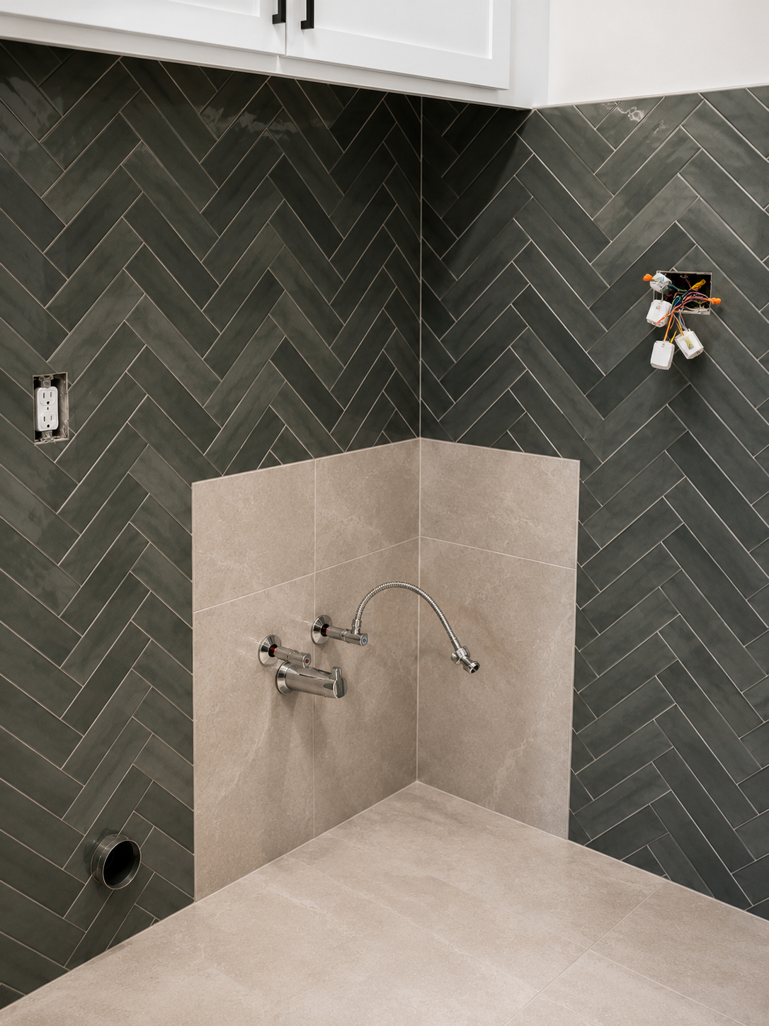 Shower remodel in progress with green herringbone tile wall