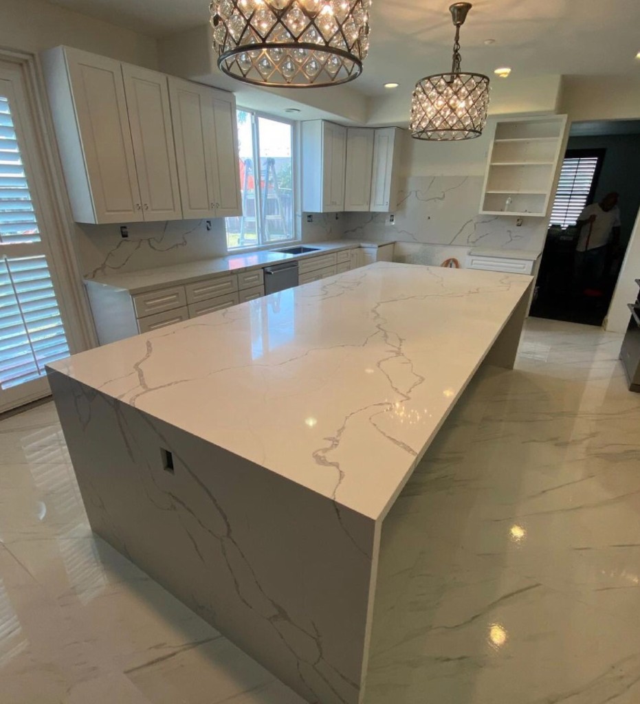 Kitchen remodel with dual crystal pendants over waterfall island