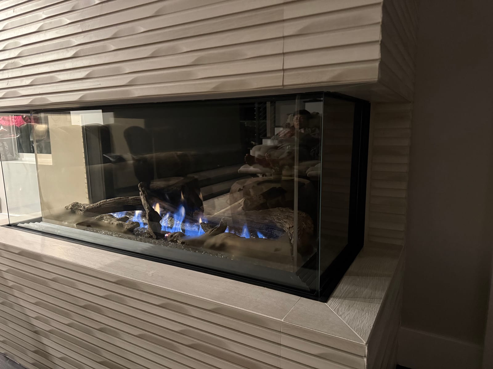 Modern fireplace installation with blue flame and tile surround
