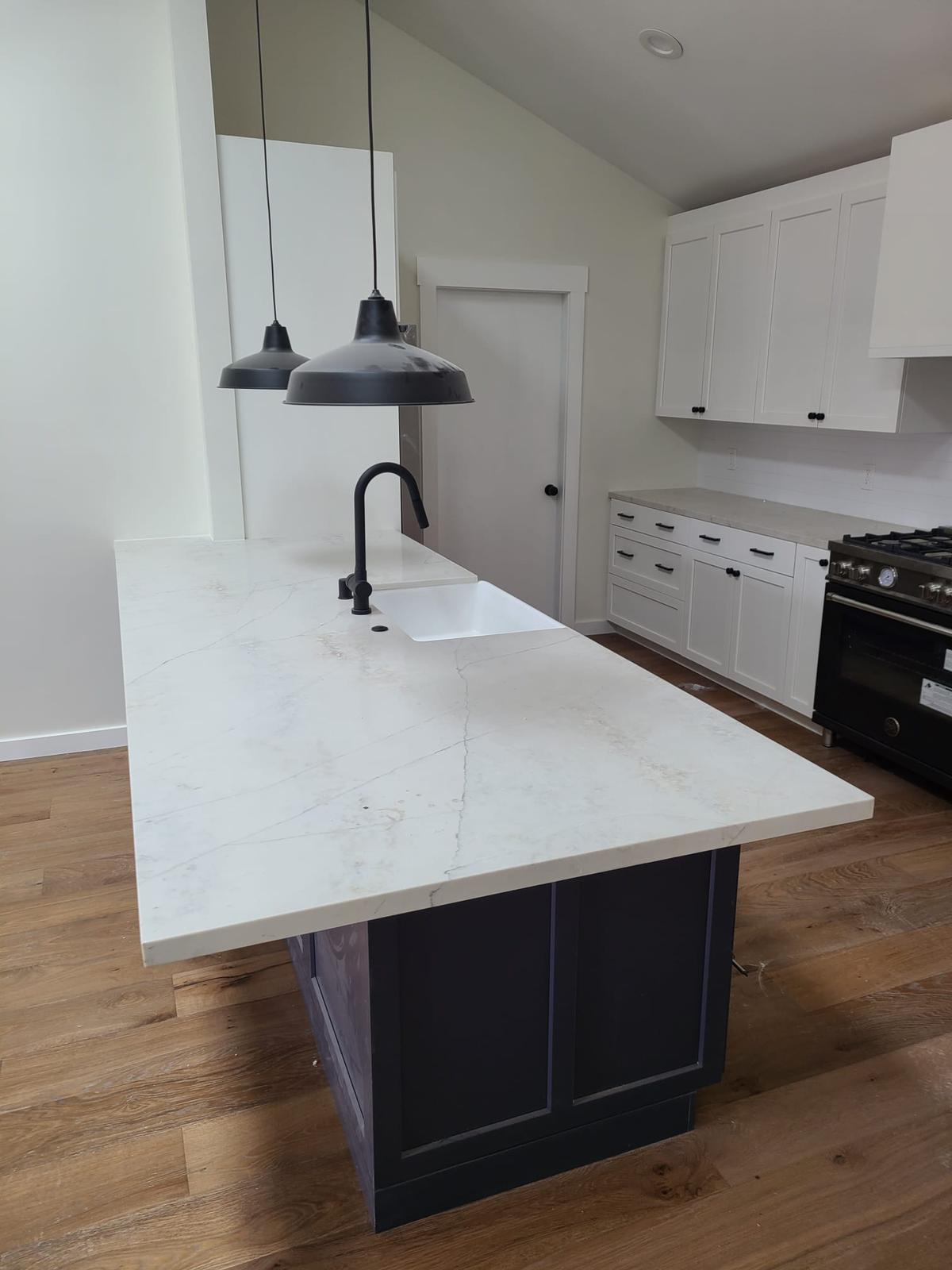 Kitchen island with marble-look quartz, undermount sink, and black faucet